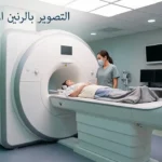 مريض على طاولة جهاز الرنين المغناطيسي داخل غرفة تصوير حديثة مع فني أشعة.
