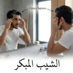 شاب عربي في العشرينيات ينظر في المرآة ويلاحظ ظهور الشيب المبكر على صدغيه