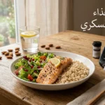 طاولة طعام عليها طبق صحي يحتوي على أرز بني وسمك مشوي وسلطة خضراء بجانب جهاز قياس سكر الدم وكوب ماء وحبات لوز مع عبارة جدول غذاء مرضى السكري