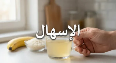 صورة غلاف مقال عن الإسهال تظهر يداً تمسك كوب محلول معالجة الجفاف مع أطعمة مناسبة في الخلفية وكلمة الإسهال بالعربية