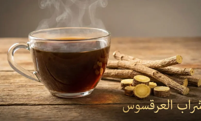 كوب شراب عرقسوس بارد بجانب جذور عرقسوس طبيعية مجففة