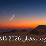 هلال رفيع يظهر في سماء مسائية برتقالية وزرقاء فوق أفق صحراوي، يمثل بداية شهر رمضان 1447 هجرياً الموافق فبراير 2026