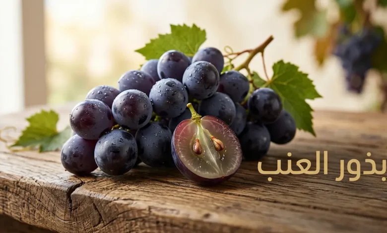 حبات عنب أرجوانية طازجة مع حبة مقطوعة تُظهر البذور الداخلية على سطح خشبي