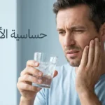 شخص يمسك كوب ماء مثلج ويضع يده على خده بتعبير ألم خفيف يوضح معاناة حساسية الأسنان مع نص حساسية الأسنان