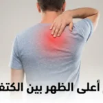 شخص بالغ يُظهر ظهره من الخلف واضعاً يده على منطقة أعلى الظهر بين الكتفين مع إبراز منطقة الألم