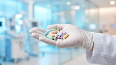 كبسولات دوائية لعلاج التليف الكيسي يحملها طبيب بعد توسيع موافقة الـ FDA