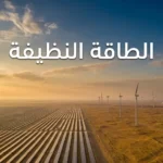 منظر جوي فوتوغرافي واقعي لحقل طاقة شمسية وتوربينات رياح في صحراء ذهبية عند غروب الشمس، مع عنوان الطاقة النظيفة في الثلث العلوي.